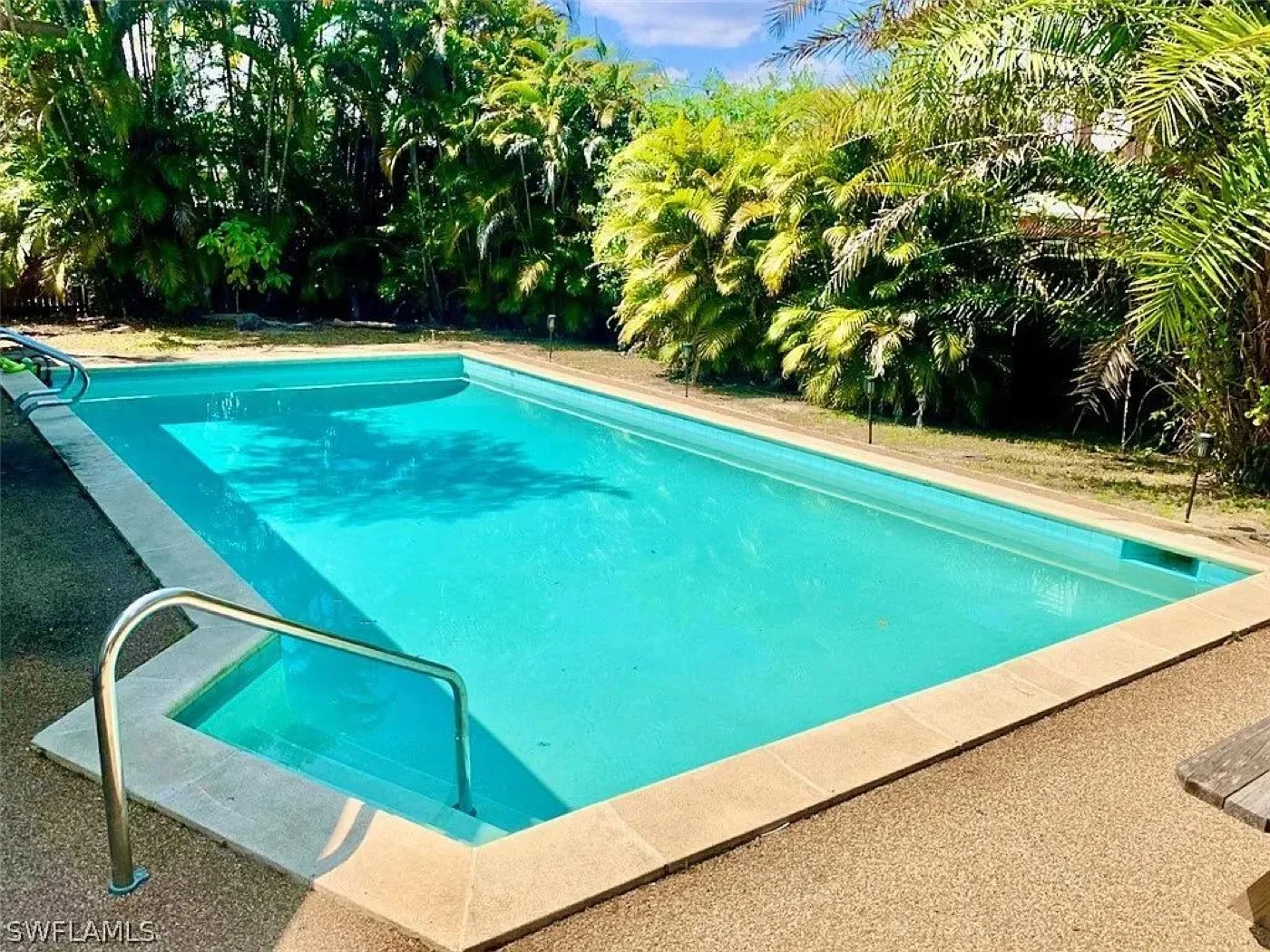 Pool before renovation: aged aqua finish, narrow concrete deck and worn coping