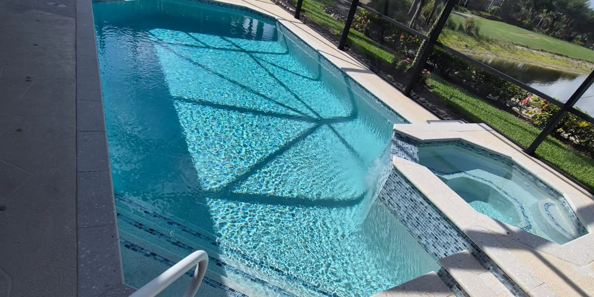 After: the same pool and spa with travertine coping, a blue and aqua glass mosaic waterline tile band carried around the spa, and a new interior finish